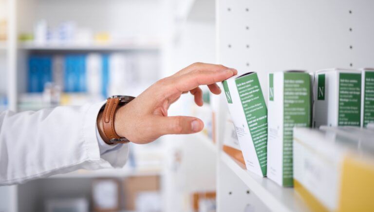 pharmacist-hand-shelf-and-boxes-with-choice-pack-2025-04-06-10-18-04-utc